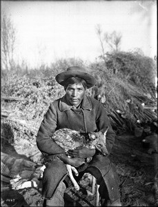 Young Chemehuevi Indian man holding a coyote, ca.1900