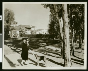 Glendale woman and dog on sidewalk, ca.1930