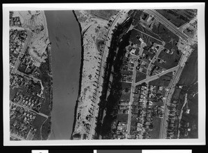 Aerial view of unidentified flooded area, showing residential blocks at left and at right, 1938