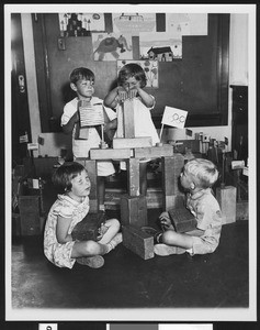 Four children using wooden building blocks, 1932