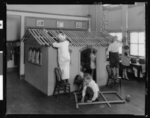 First grade children building a Celotex house at Alexandria Avenue School