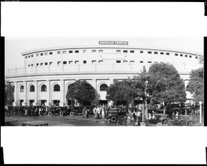 Exterior view of the Angelus Temple, showing a crowd and automobiles, 1925-1935