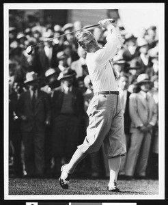 A player at a golf tournament while a crowd is watching, ca.1920