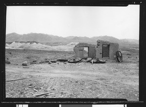 Adobe remains and abandoned wagon wheels in the desert