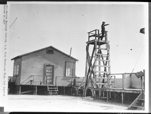 Man standing on an observation platform at the "old" Marine Exchange, 1917