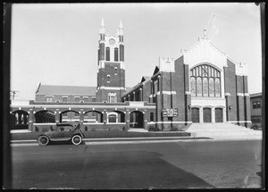 Exterior view of the Wilshire Presbyterian Church, showing a parked car, 1920-1940