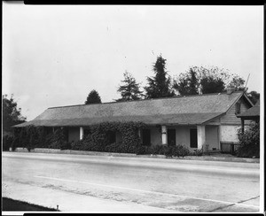 Exterior view of the adobe home Casa Yorba, its facade covered with creeping vines, ca.1940