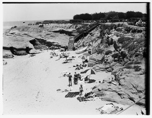 People sunbathing on the rocky shoreline at Laguna Beach, ca.1933