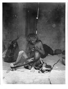 Old blind man winding yarn with a young girl watching, Arizona, ca.1898