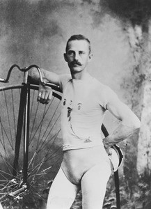 Portrait of James Lancaster of the Los Angeles Bicycle Club posing with a high wheel bicycle, November 1886