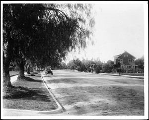 View of a broad dirt boulevard in Corona with a "Tourist" car parked along the side, ca.1908