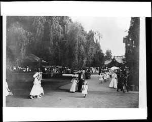 Well-dressed families strolling through Oakland's Idora Park, ca.1900