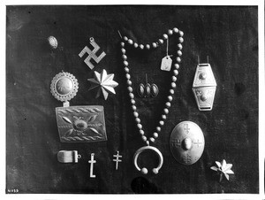 Collection of thirteen pieces of Navajo Indian silver jewelry on display, ca.1900