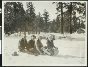 Four people on a toboggan in the snow, ca.1930