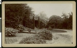 A dirt driveway surrounded by a garden, ca.1910