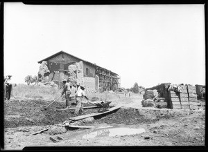 Men mixing mud for adobe bricks to renovate the San Fernando Mission, July 29, 1927