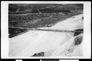 Aerial view of flood in Azusa, showing damage of San Gabriel Railroad Bridge over a river, California, 1938