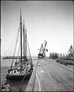 A lumber schooner, the Azalea Sanfrancisco, anchored at the Redondo Beach railroad and shipping wharf, ca.1904-1910