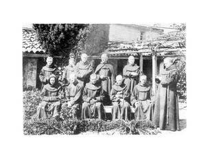 Father O'Keefe and a group of monks in the garden at Mission San Luis Rey de Francia, ca.1900