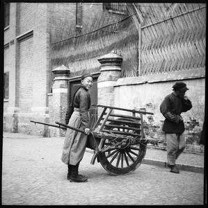 Young man pushing a wheelbarrow taxi, China, ca.1900