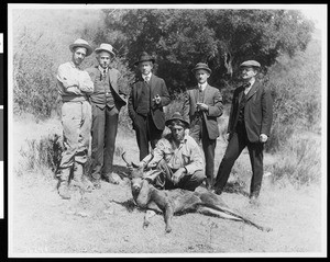 A hunting party of men showing a deer they killed, ca.1920