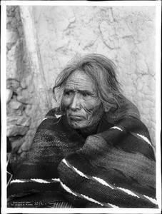 An old Navajo brave huddled in a blanket, ca.1901