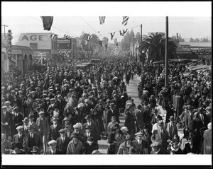 Huge throng of people filing down the street after the Tournament of Roses Parade, Pasadena, ca.1925