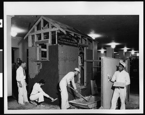 Instructional exhibit by Frank Wiggins Trade School, showing students and teacher, ca.1920-1929