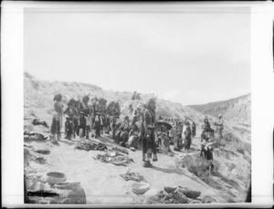 Eight Hopi Indian flute players standing on the side of a hill in the Hopi Indian flute ceremony at Oraibi, ca.1901