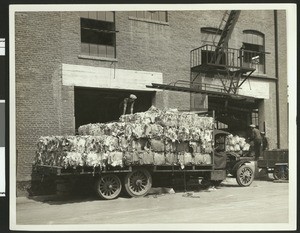 Unloading piles of old newspapers from a truck at the Fibreboard Products Comoany, ca.1930