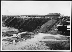 View of Hammond Lumber Company, located at the edge of a large pit, 1900