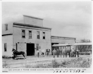 Portrait of men standing outside of a Vernon Street Railway Car barn on the corner of 22nd Street and Central Avenue, Los Angeles, ca.1890