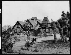 Exterior view of the Antelope Valley Indian Museum, showing a woman and dogs