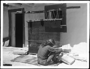 Hopi man weaving cloth for a woman's dress in the village of Shonguapavi, ca.1901