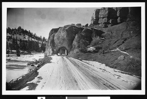 Road leading into Bryce Canyon Park, with a vehicle passing through a hole in the rock, Utah