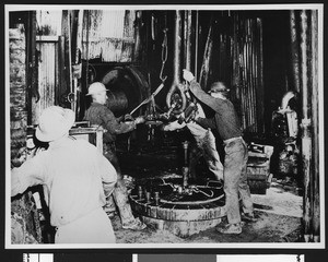 Men working in an oil refinery, ca.1940