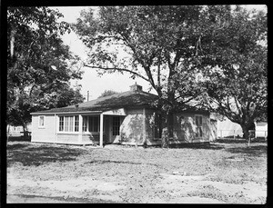 An exterior view of a one-story house, showing an extrance porch