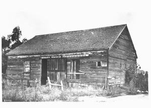 Exterior view of a single-story building in dilapidated condition, ca.1910