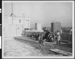 Man plunging into a pool atop an apartment house, ca.1930