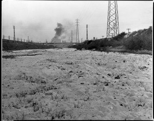 View of the bed of the Los Angeles River near Seventh Street, showing a bridge in the background