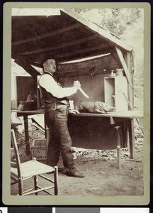 A fishing club member preparing to carve a pig, ca.1910-1920