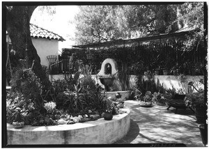 View of a fountain in the courtyard of an adobe house near the Hotel Raymond in Pasadena, July 31, 1934