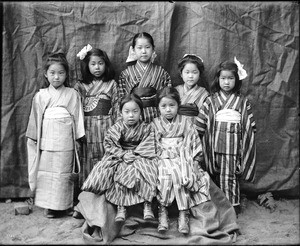 Portrait of seven young Japanese girls wearing kimonos at Mission School, ca.1900