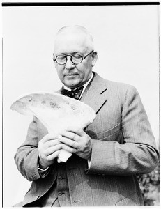 Man holding what appears to be a bone at the Pacific Southwest Museum