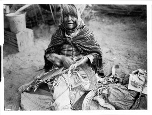 Chemehuevi Indian woman repairing a papoose basket, ca.1900