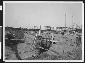 Exterior at Llewellyn Iron Company, showing workers at construction site, ca.1930