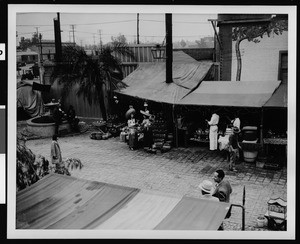 Olvera Street, showing shoppers wearing sombreros, ca.1940-1949