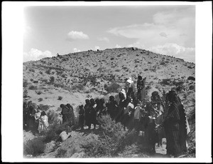 Group of about 25 women standing on the side of a hill in the Hopi Indian flute dance at Oraibi, ca.1901