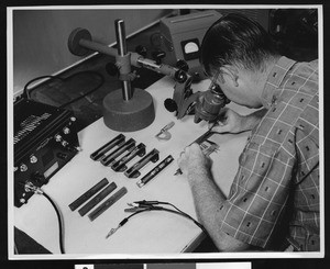 Man at work in what seems to be an electronics-oriented office, ca.1950