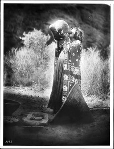 Young Havasupai Indian women drinking from a water jug, ca.1900